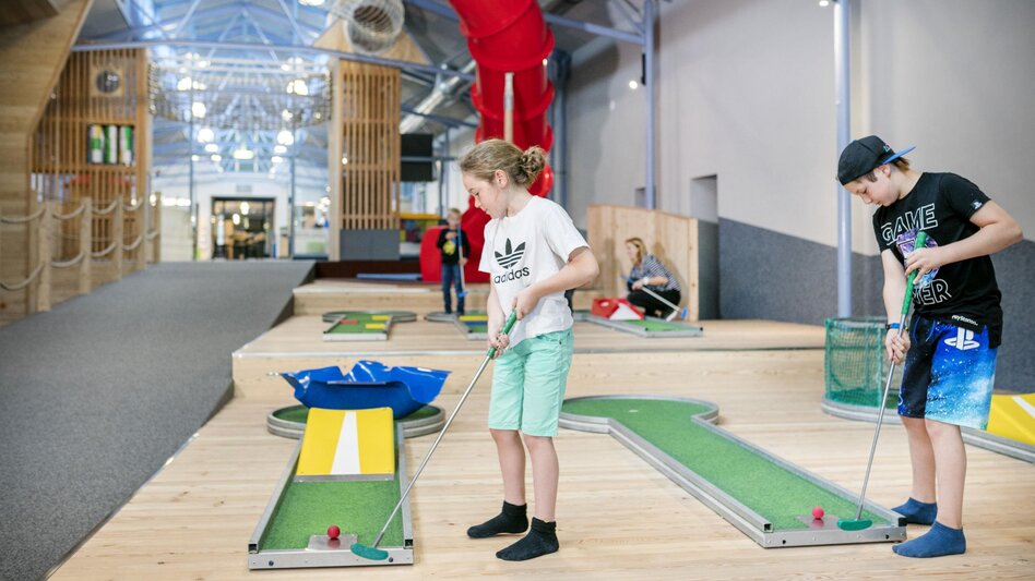 Kinder beim Indoor-Minigolf im JUFA Hotel Vulkanland in Gnas im Thermen- & Vulkanland Steiermark. | © JUFA Gnas