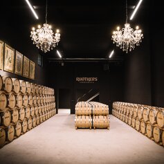 Whiskyfässer im stilvollen Reifekeller von David Gölles - House of Whiskey in Riegersburg mit edlen Kronleuchtern – handwerkliche Destillationskunst im Thermen- & Vulkanland Steiermark.