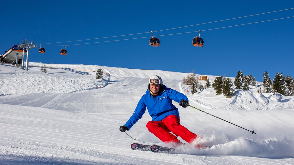Skifahrer carvt über die Skipiste