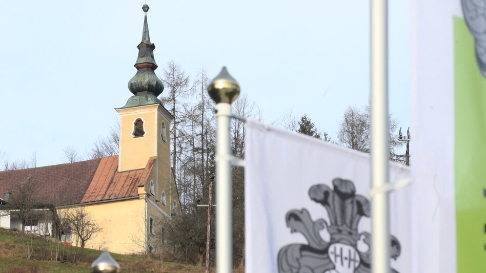 Im Vordergrund Fahnen mit Sicht auf die Sebastianikircherl | © TV ERZBERG LEOBEN
