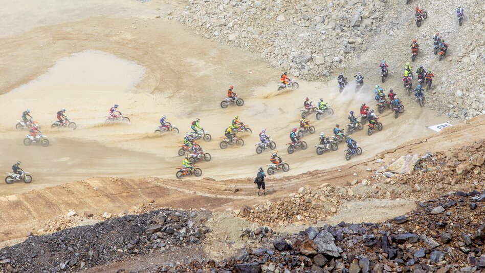 Viele Motorcrossfahrer fahren beim Erzberg Rodeo einen Hügel hinauf. Sie produzieren sehr viel Staub. | © Abenteuer Erzberg