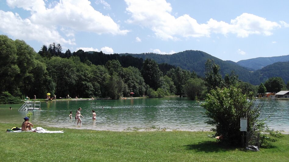 Ein Badeteich an einem Sommertag mit Gästen