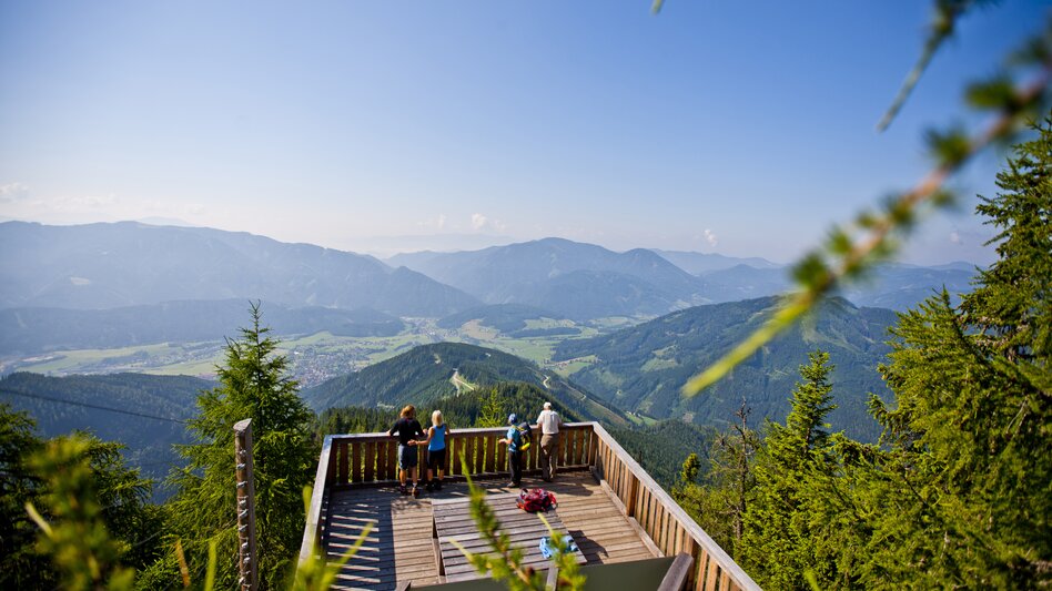 Vier Menschen stehen auf einer Aussichtsplattform und bestaunen den Weitblick