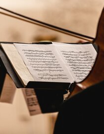 music stand with sheet music, a cello slightly blurred in the foreground