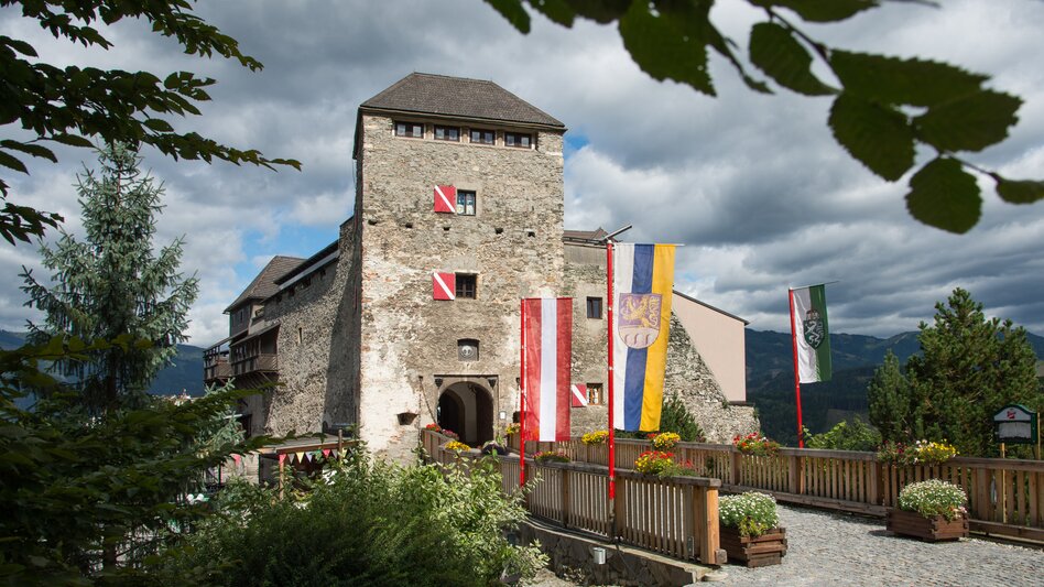 Eine Burg mit Zugbrücke, Blumen und Fahnen