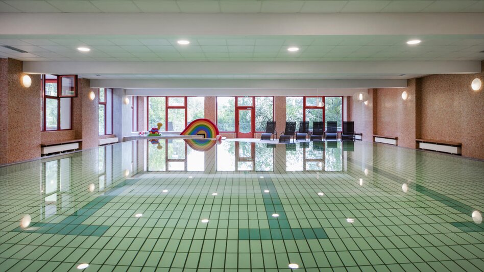 Das Schwimmbad im JUFA Hotel am Sigmundsberg mit kleinem Kinder-Bereich und Liegen
