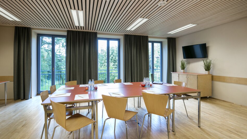 Ansicht des Seminarraums im JUFA Hotel am Sigmundsberg mit Tisch und Sesseln in Block-Form