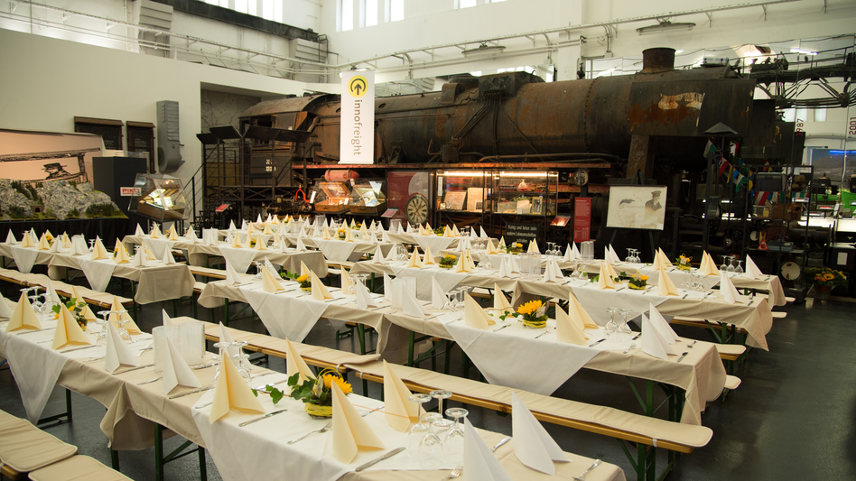 Ansicht schön gedeckter Biertische im SÜDBAHN Museum, im Hintergrund sieht man einen alten Eisenbahnwaggon