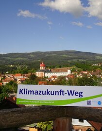 Klimazukunft-Weg: Wegweiser im Hintergrund Schloss und Pfarrkirche Pöllau | © Oststeiermark Tourismus | Reinhold Schöngrundner | © Oststeiermark Tourismus
