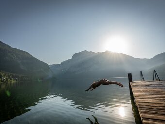 Eine Frau macht einen Kopfsprung in den Altausseer See