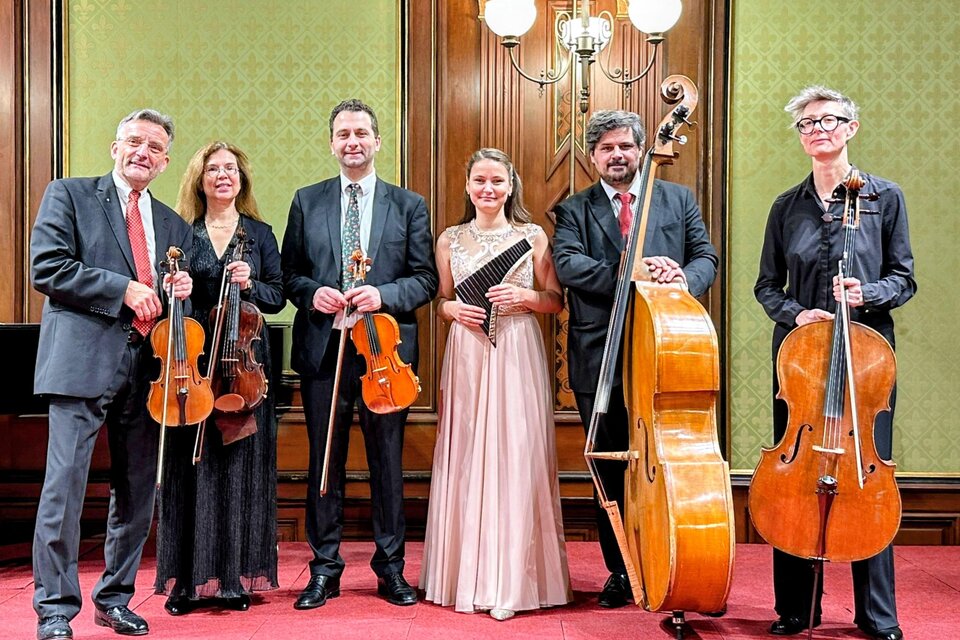 Drei Frauen sitzen auf einer Bank und lächeln. Neben ihnen liegt ein Cello auf dem Boden. | © Concilium musicum Wien