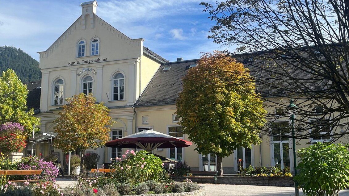 Eine Vorderansicht vom Veranstaltungsort Kur-& Congresshaus in Bad Aussee mit einem Teil vom Kurhausplatz und Kurpark, in dem auch der Floh- und Antikmarkt stattfindet.  | © Tourismusbüro Bad Aussee
