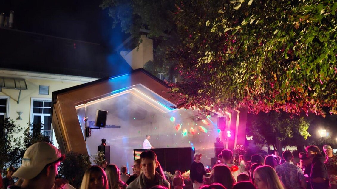 <p>Das Sommernacht Clubbing im Kurpark Bad Aussee. DJ BernArdo steht in der Kleinkunstbühne und sorgt mit roten  Lichteffekten und Nebel für Open-Air-Feeling. Zahlreiche Besucher genießen die Musik und feiern gemeinsam unter freiem Himmel.</p> | © Stadtmarketing Bad Aussee, stadtmarketing-badaussee.at