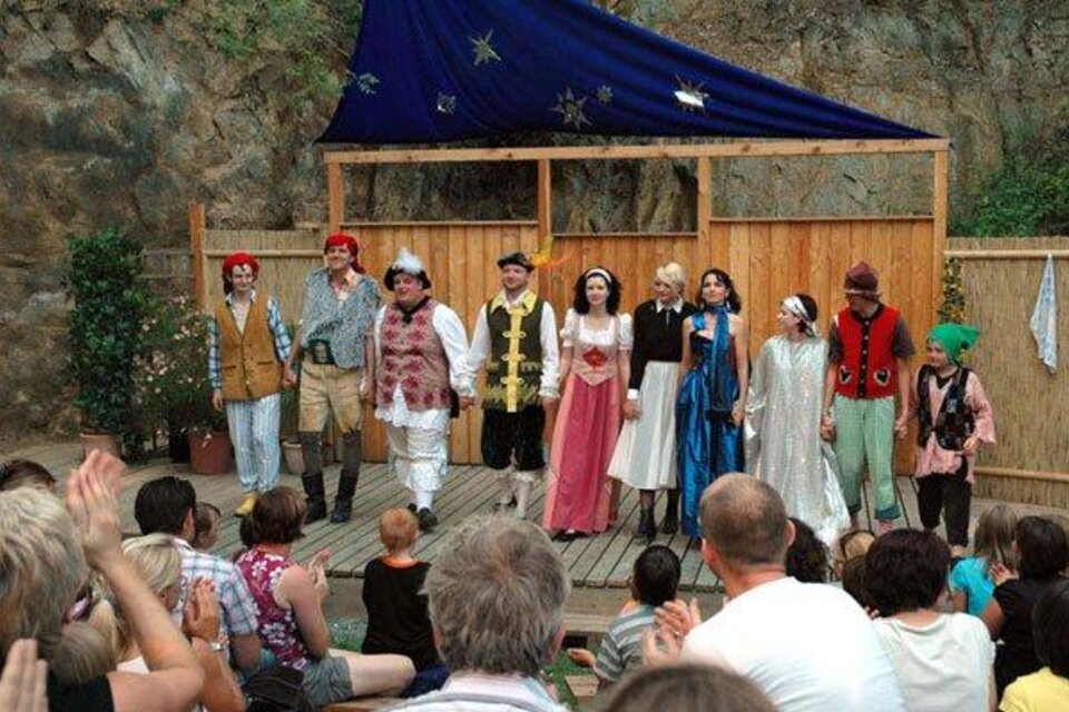 Eine Gruppe von Schauspielern steht auf einer Bühne und präsentiert eine Theateraufführung. Das Publikum schaut gespannt zu und applaudiert. | © Kulturverein "Die Thalburger"