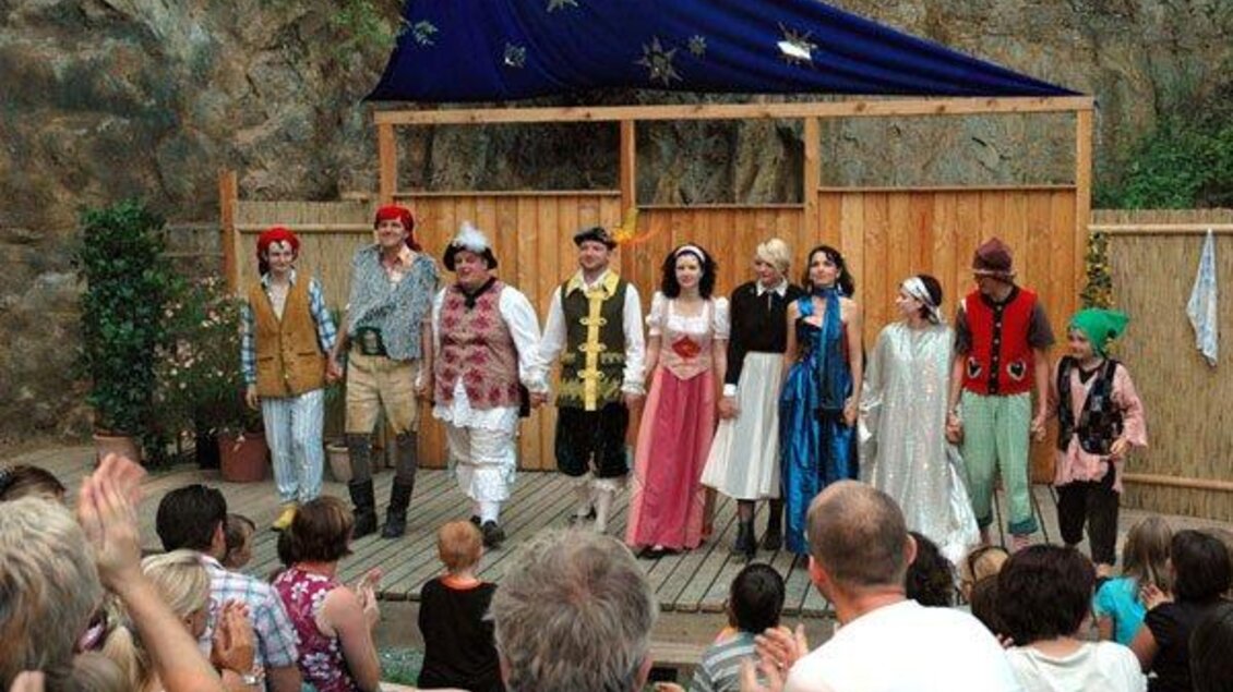 Eine Gruppe von Schauspielern steht auf einer Bühne und präsentiert eine Theateraufführung. Das Publikum schaut gespannt zu und applaudiert. | © Kulturverein "Die Thalburger"