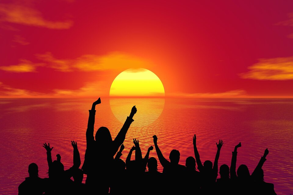 Eine Gruppe von Menschen feiert vor einem Sonnenuntergang. Der Himmel ist rot und orange, und die Silhouetten zeigen Freude und Begeisterung. | © Pixabay