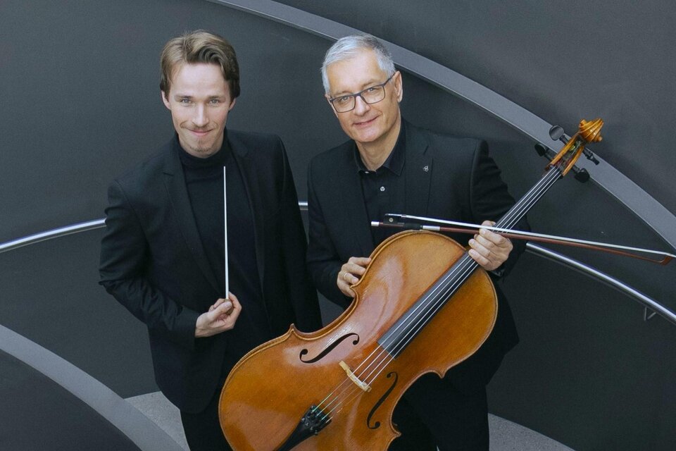 Zwei Musiker stehen auf einer Treppe. Der Mann links hält einen Dirigentenstab, der Mann rechts spielt ein Cello. | © Bettina Hoffellner