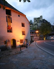 Altes Haus und Burgruine im Hintergrund