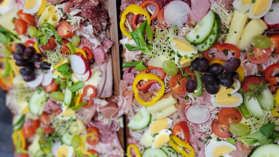 Ein reichhaltiges Plattengericht mit verschiedenen Aufschnittsorten, Käse und frischem Gemüse. Bunte Zutaten wie Paprika, Tomaten und Trauben sorgen für eine ansprechende Präsentation. | © Hirschgehege Hauser