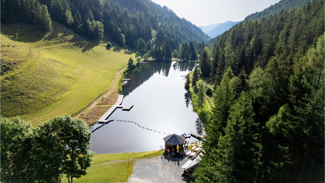 Ein ruhiger See, umgeben von Bergen und Wäldern. An einem Ufer steht eine kleine Hütte. | © TV Murau