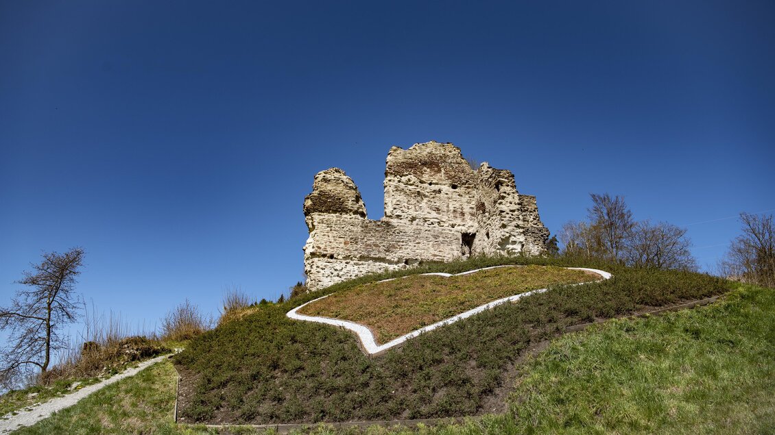 Eine alte Ruine auf einem Hügel, umgeben von grünen Wiesen. Der klare blaue Himmel bildet einen schönen Hintergrund. | © Anita Fössl