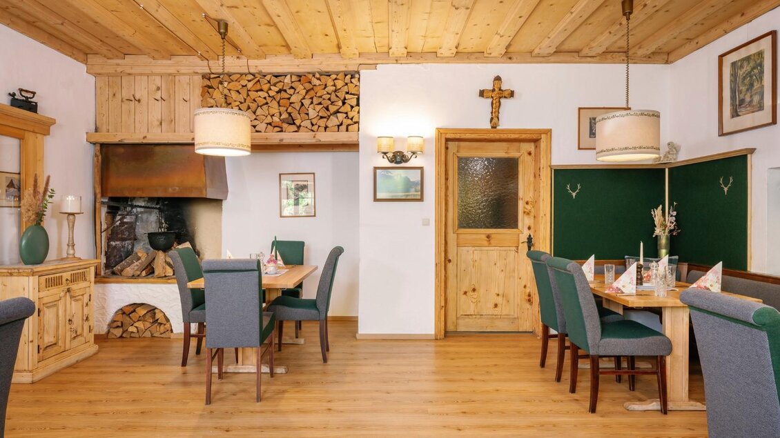 Ein gemütliches Restaurant mit Holzmöbeln und einer warmen, einladenden Atmosphäre. Der Raum ist mit Bildern und einem Kamin dekoriert. | © Gasthaus Stöckl