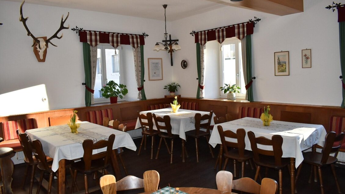 Ein gemütlicher Speisesaal mit mehreren Tischen und Stühlen. Die Wände sind dekoriert und es gibt Pflanzen auf den Fenstern. | © Elisabeth Moser