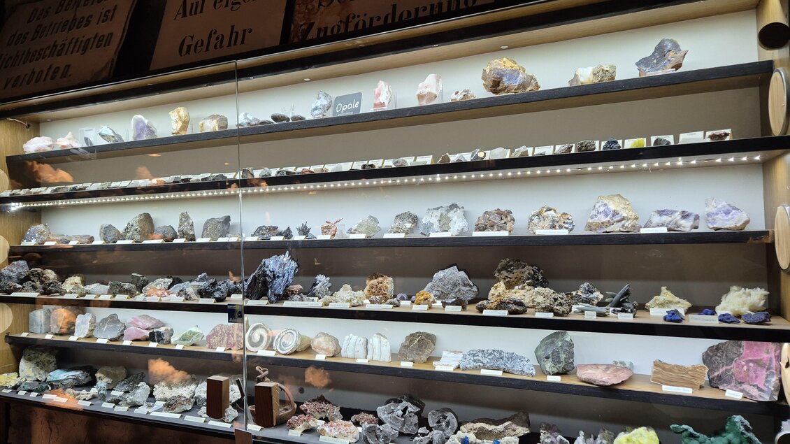 Eine Vitrine mit verschiedenen Mineralien und Edelsteinen in unterschiedlichen Farben. Die Steine sind ordentlich auf Regalen angeordnet und durch eine Beleuchtung hervorgehoben. | © TVB Murau