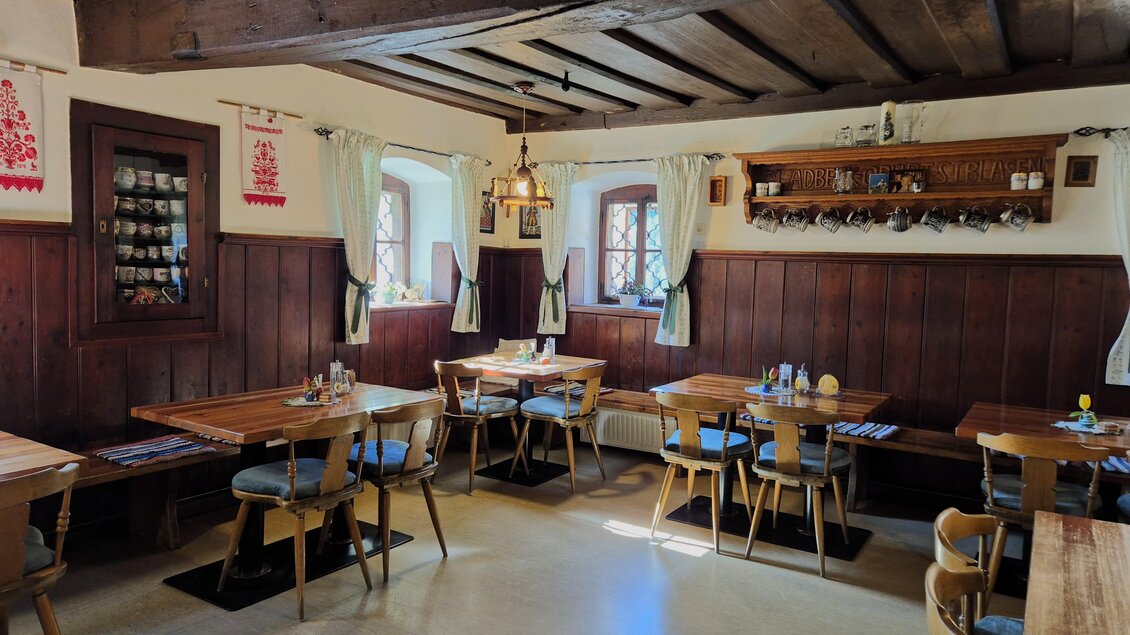 Ein gemütliches Restaurant mit Holzmöbeln und sanfter Beleuchtung. Die Wände sind mit traditionellem Dekor geschmückt. | © TV Murau