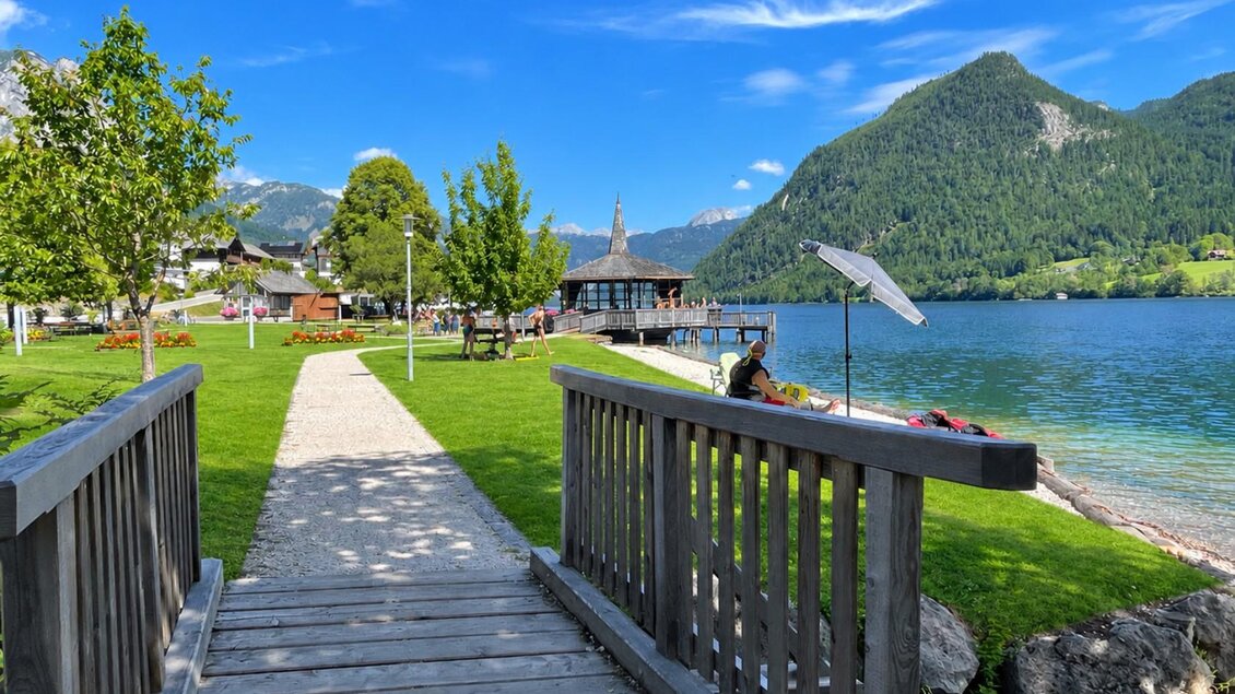 Ein malerischer See mit grünen Wiesen und Bergen im Hintergrund. Ein Holzsteg führt zum Wasser und lädt zum Entspannen ein. | © Tourismusverband Ausseerland