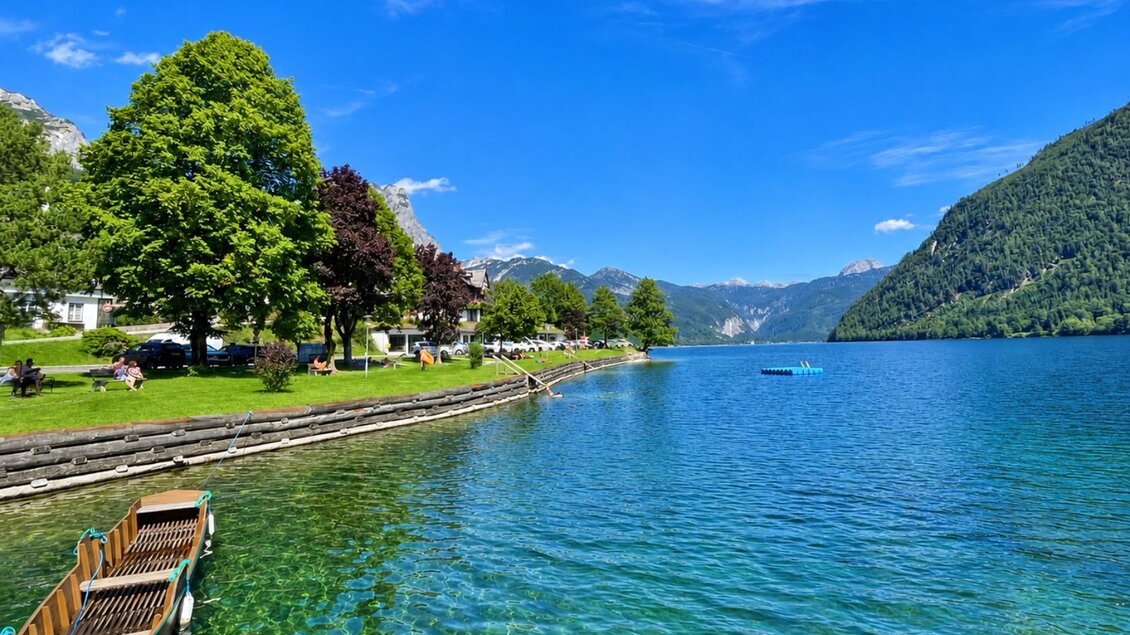 Ein klarer See umgeben von grünen Bäumen und Bergen. Am Ufer sind Boote zu sehen und es ist herrliches Wetter. | © Tourismusverband Ausseerland