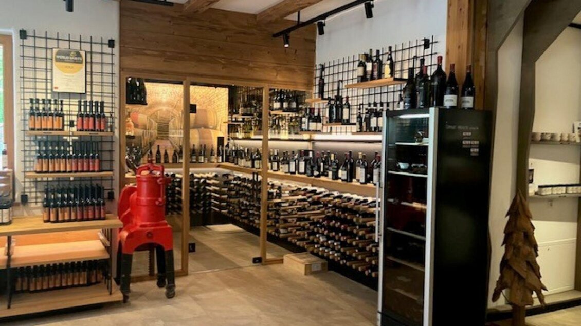 Der Genussladen mit Weinecke mit einer großen Auswahl an Weinflaschen. Die Regale sind ordentlich angeordnet, und es gibt einen Kühlschrank für gekühlte Getränke.</p> | © TVB Ausseerland Salzkammergut (c) Heike Temmel