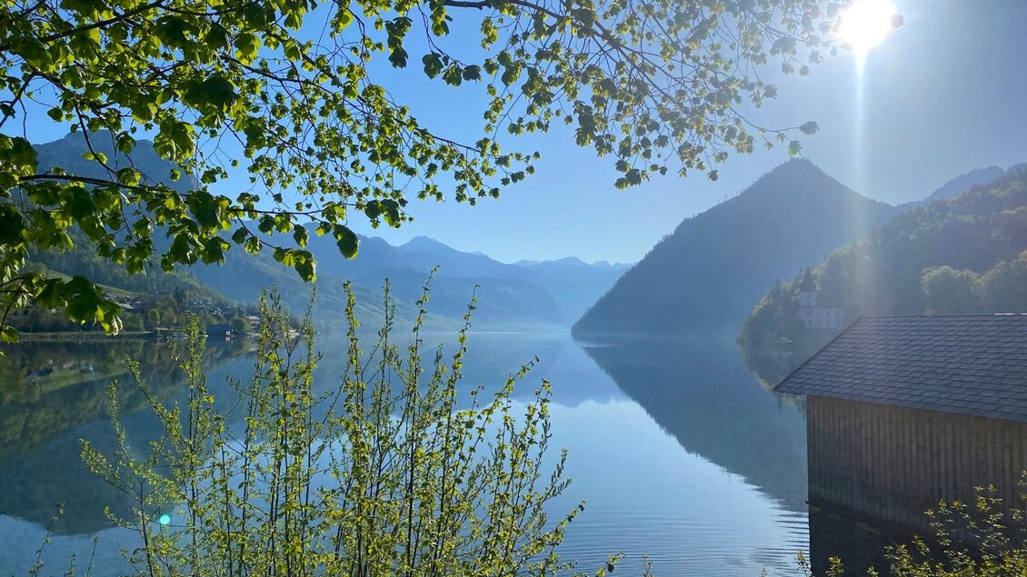 <p>Der ruhige Grundlsee im Ausseerland Salzkammergut umgeben von Bergen und Bäumen an einem traumhaften Frühlingstag. Die Sonne scheint hell am klaren blauen Himmel.</p> | © Bettina Scheck