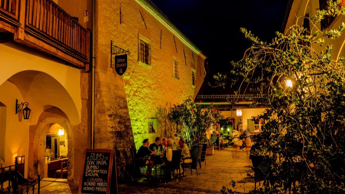Abendliche Gastronomie in einem historischen Innenhof mit Arkaden und stimmungsvoller Beleuchtung in der Altstadt von Bad Radkersburg. | © Zehnerhaus Bad Radkersburg