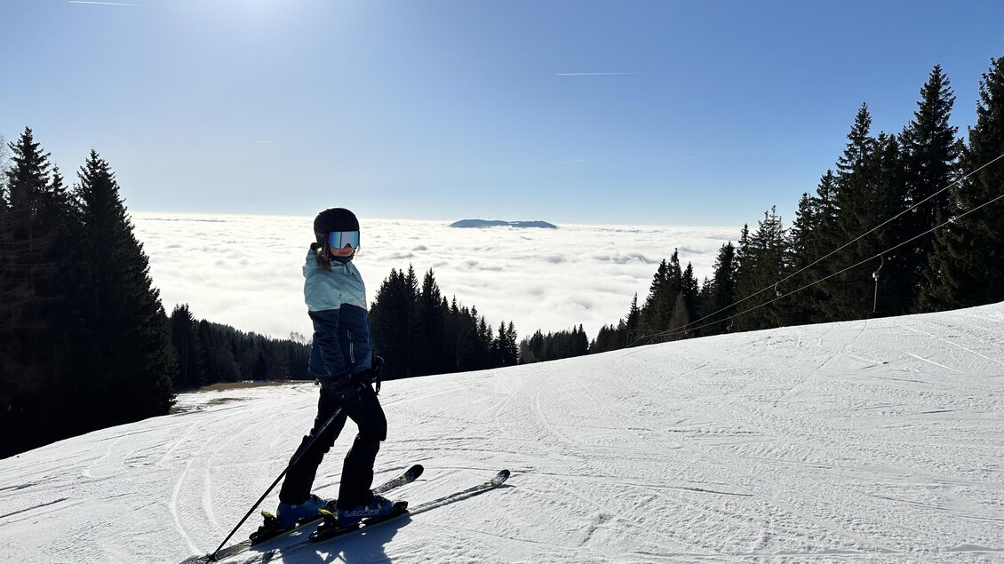 Eine Schifahrerin auf der Piste mit Nebel im Tal im Hintergrund. | © Oststeiermark Tourismus