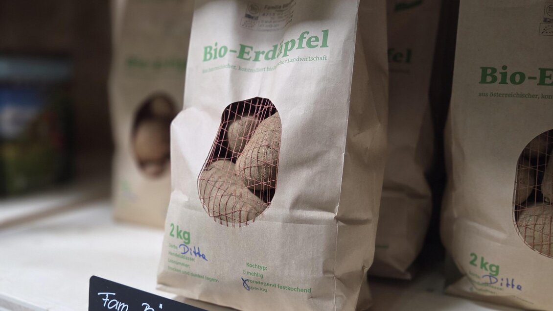 Bio-Kartoffeln in braunen Papiertüten auf einem Regal. Die Tüten sind mit einem Etikett und dem Hinweis "speckig" versehen. | © Karl August
