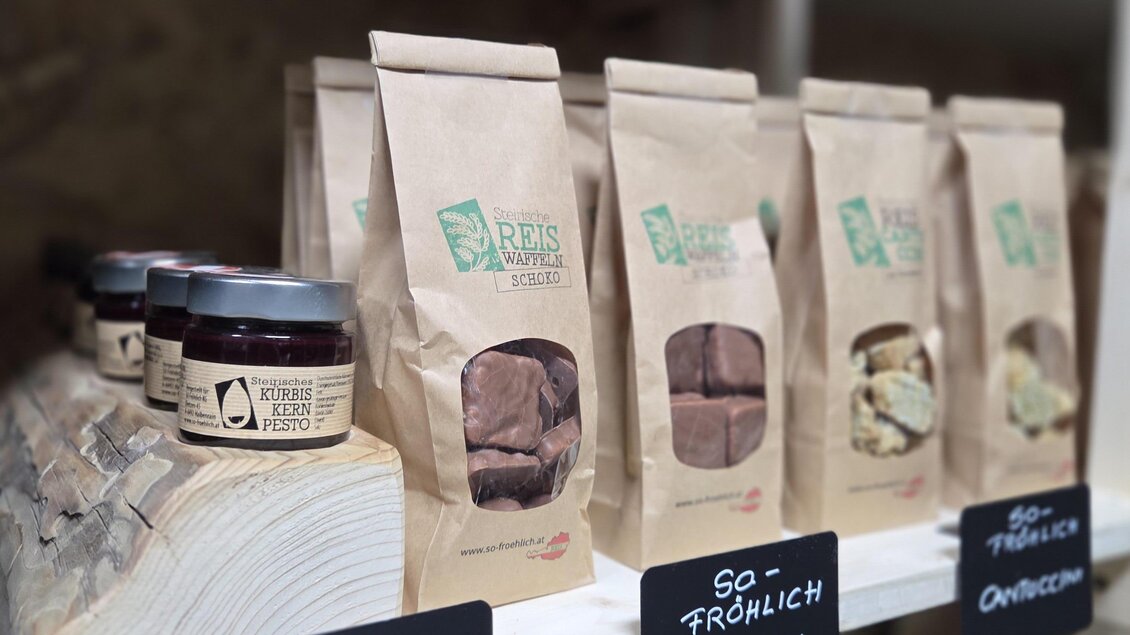Ein Regal mit verschiedenen Lebensmitteln in umweltfreundlicher Verpackung. Sichtbar sind Produkte wie Pesto und Snacks mit klaren Etiketten. | © Karl August