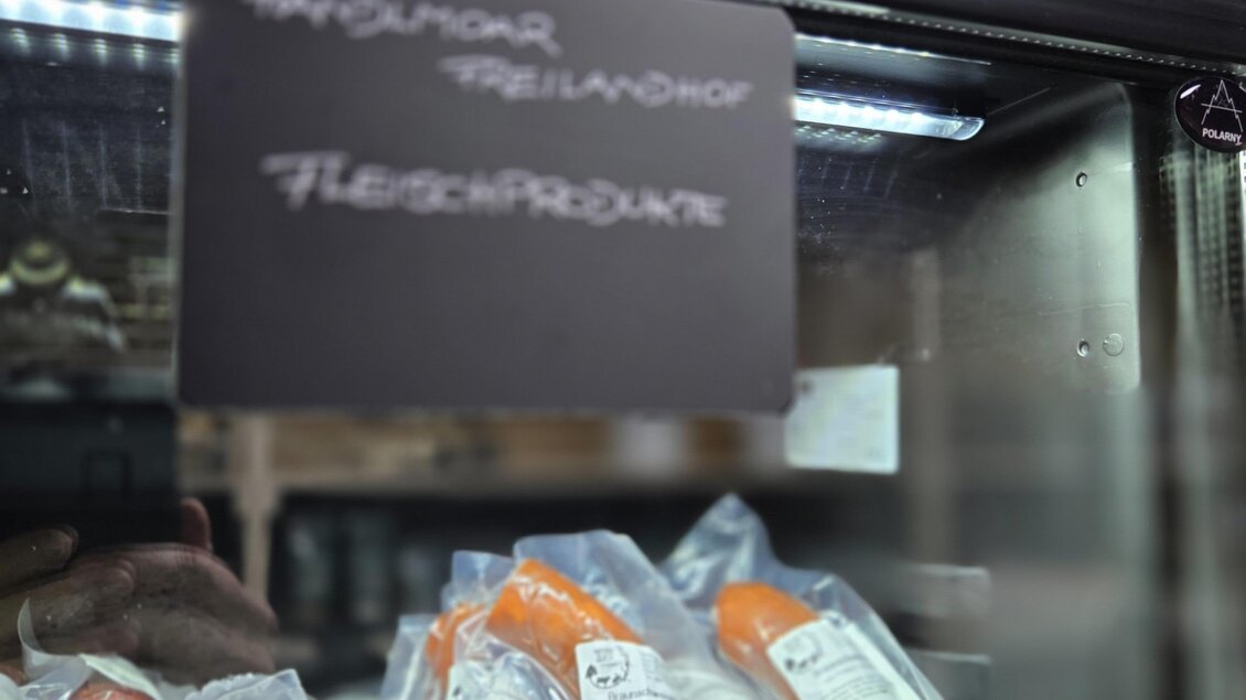 In einer Kühltruhe liegen vakuumverpackte Wurstwaren. Darüber ist ein Schild mit der Aufschrift "FLEISCHPRODUKTE". | © Karl August