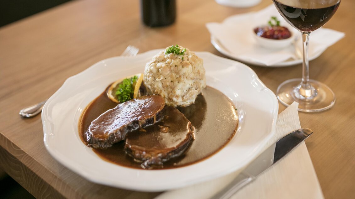 Man sieht eine heiße Hauptspeise mit Knödel, Soße und Fleisch.  | © Latschenhütte