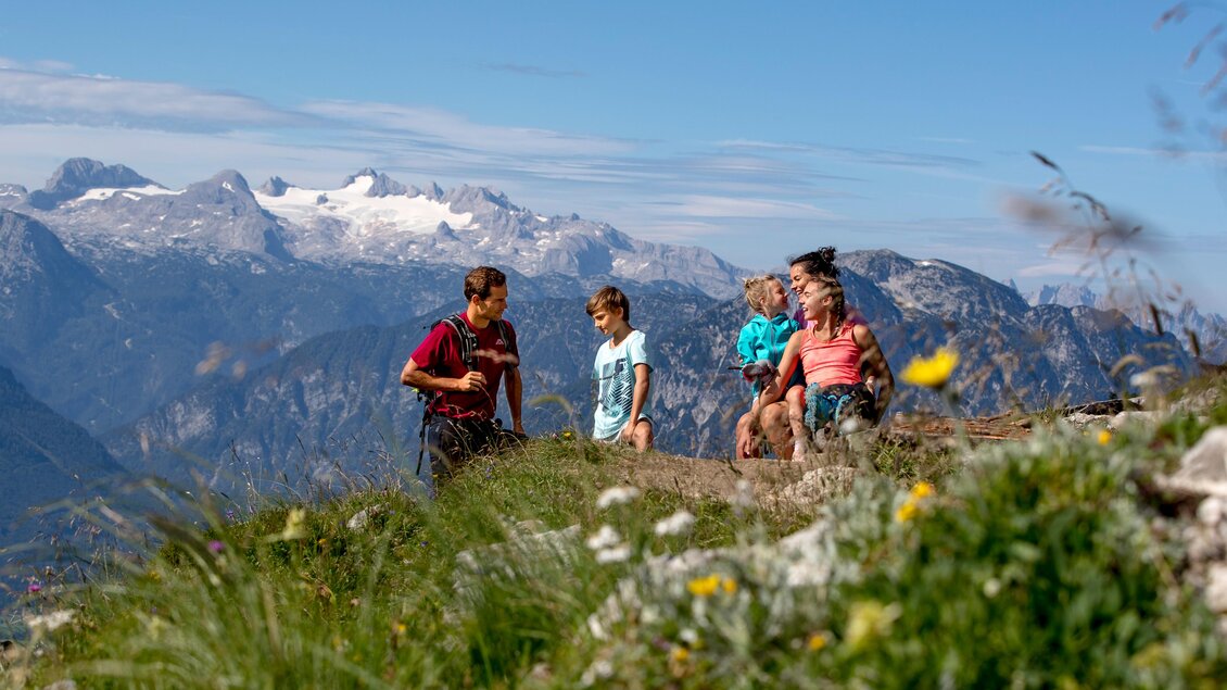 <p>Eine Familie wandert durch die schöne Berglandschaft mit blühenden Wiesen am Loser in Altaussee. Im Hintergrund ist das schneebedeckte Dachsteinmssiv zu sehen.</p> | © TVB Ausseerland-Salzkammergut/Tom Lamm