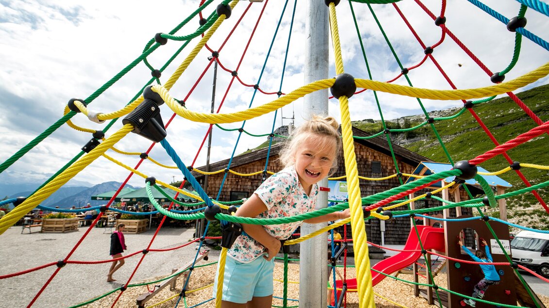 <p>Ein Mädchen spielt auf dem bunten Klettergerüst am Loser in Altaussee. Im Hintergrund sind weitere Spielgeräte neben der Loseralm inmitten der Landschaft des Ausseerlandes.</p> | © TVB Ausseerland-Salzkammergut/Tom Lamm