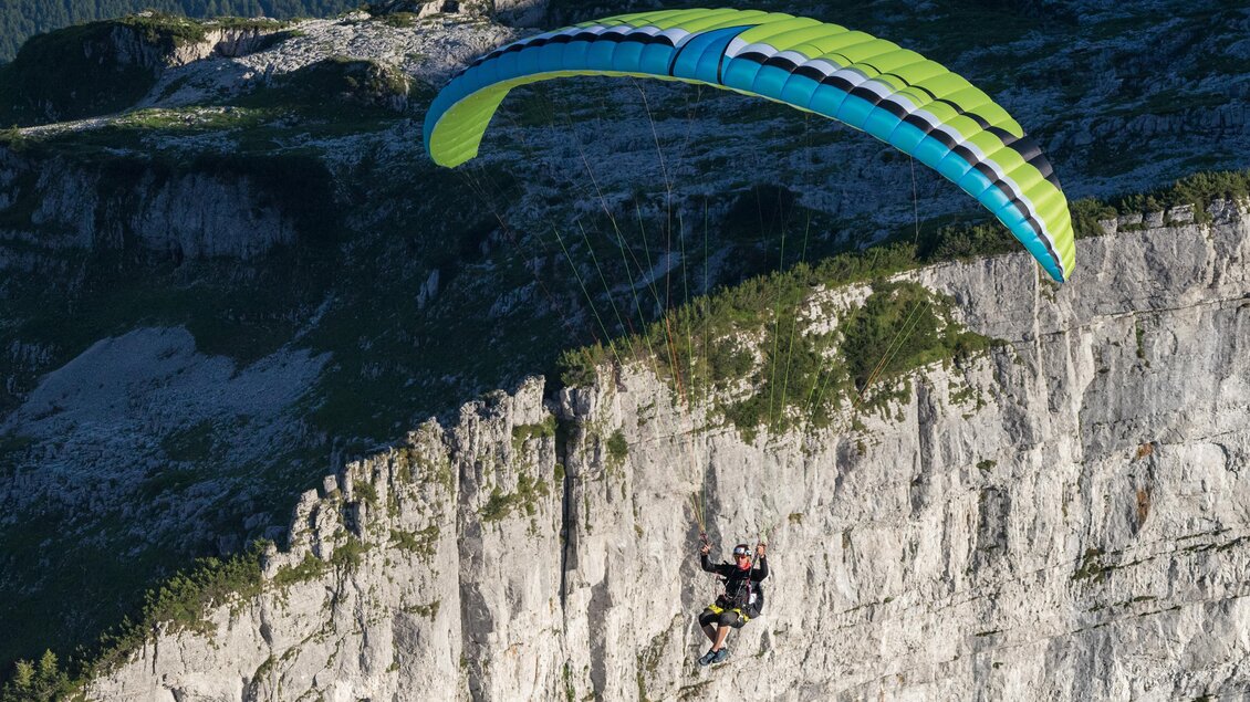 <p>Ein Paragleiter schwebt über der steilen Felswand des Altausseer Hausberges, dem Loser. Der bunte Gleitschirm hebt sich von der beeindruckenden Berglandschaft des Ausseerlandes ab.</p> | © Loser Bergbahnen Altaussee/F. Loitzl