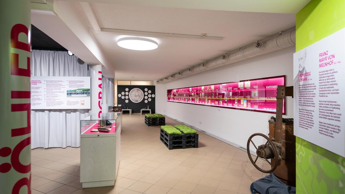 Ein modernes Ausstellungszimmer mit pinken Regalen und Ausstellungsstücken. Die Wände sind in hellen Farben gestaltet und es gibt verschiedene Informationsgrafiken. | © Stadtgemeinde Kapfenberg