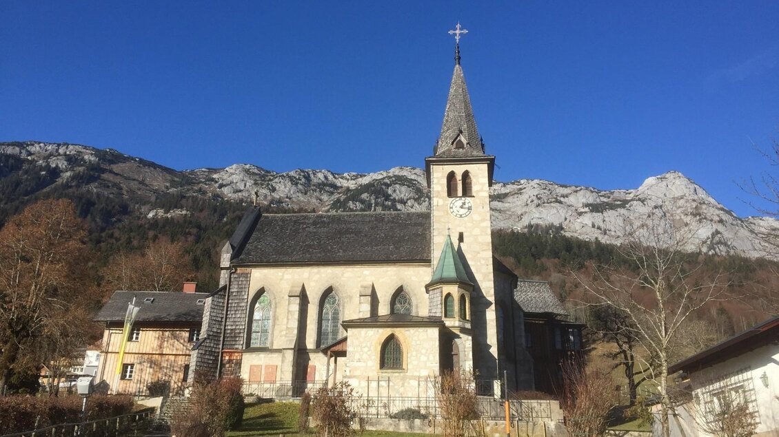 Eine schöne Kirche mit einem hohen Turm, umgeben von Bergen und klarem blauem Himmel. Die Landschaft ist ruhig und malerisch. | © Bettina Scheck