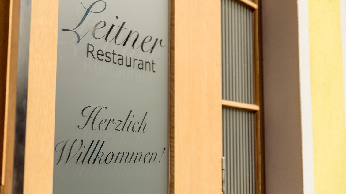 Eine elegante Restauranttür mit einem einladenden „Herzlich Willkommen!“. Der Name des Restaurants, „Leitner“, ist gut sichtbar. | © Restaurant Leitner