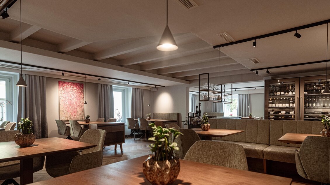 Gastraum im Restaurant Wörgötter in Ligist mit Holztischen, gepolsterten Sitzbänken, Pflanzen und Weinschränken | © Die Abbilderei