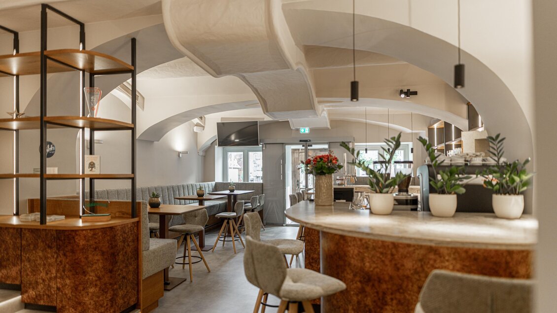 Barbereich im Restaurant Wörgötter in Ligist mit geschwungener Theke, Barhockern, Sitznischen und weißer Gewölbedecke | © Die Abbilderei