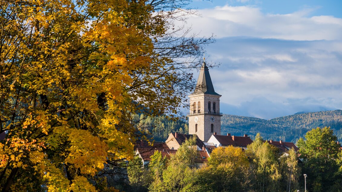 Ein hoher Turm ragt in den Himmel, umgeben von Kindern, die mit den Händen nach ihm zeigen. Die Szenerie vermittelt ein Gefühl von Neugier und Staunen. | © Claudia Bachler