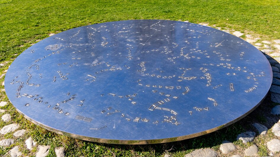 Reflektierende ARTSAT Scheibe mit künstlerischen Darstellungen.