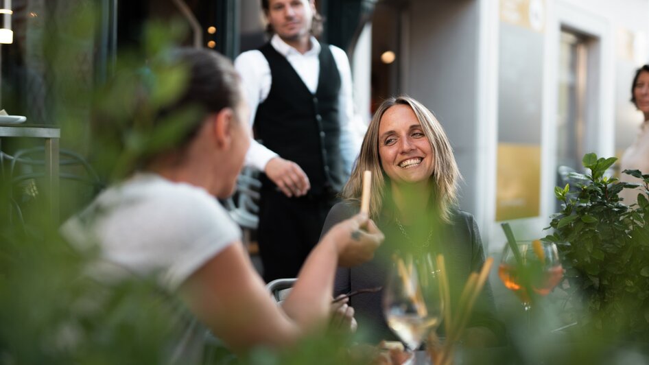 Freunde genießen das Essen und Trinken in der Auenbrugger Weinbar.